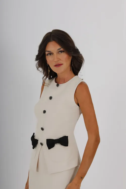 Conjunto midi de top y falda lápiz en crepe, la definición de sofisticación y estilo. Los botones joya recorren de forma elegante desde el escote hasta la cintura. Presenta un escote redondo y unos lazos de tafeta en el top que completan el diseño.