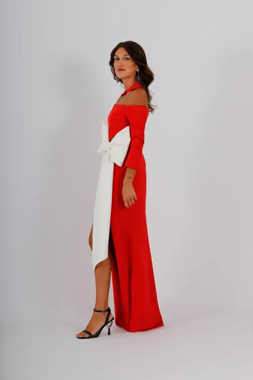 Vestido largo y ceñido en crepe con abertura lateral en la parte delantera. Destaca por un cut-out en el escote que añade un toque moderno. Las mangas francesas combinan con la lazada blanca de la cintura dando lugar a un diseño elegante y sofisticado.