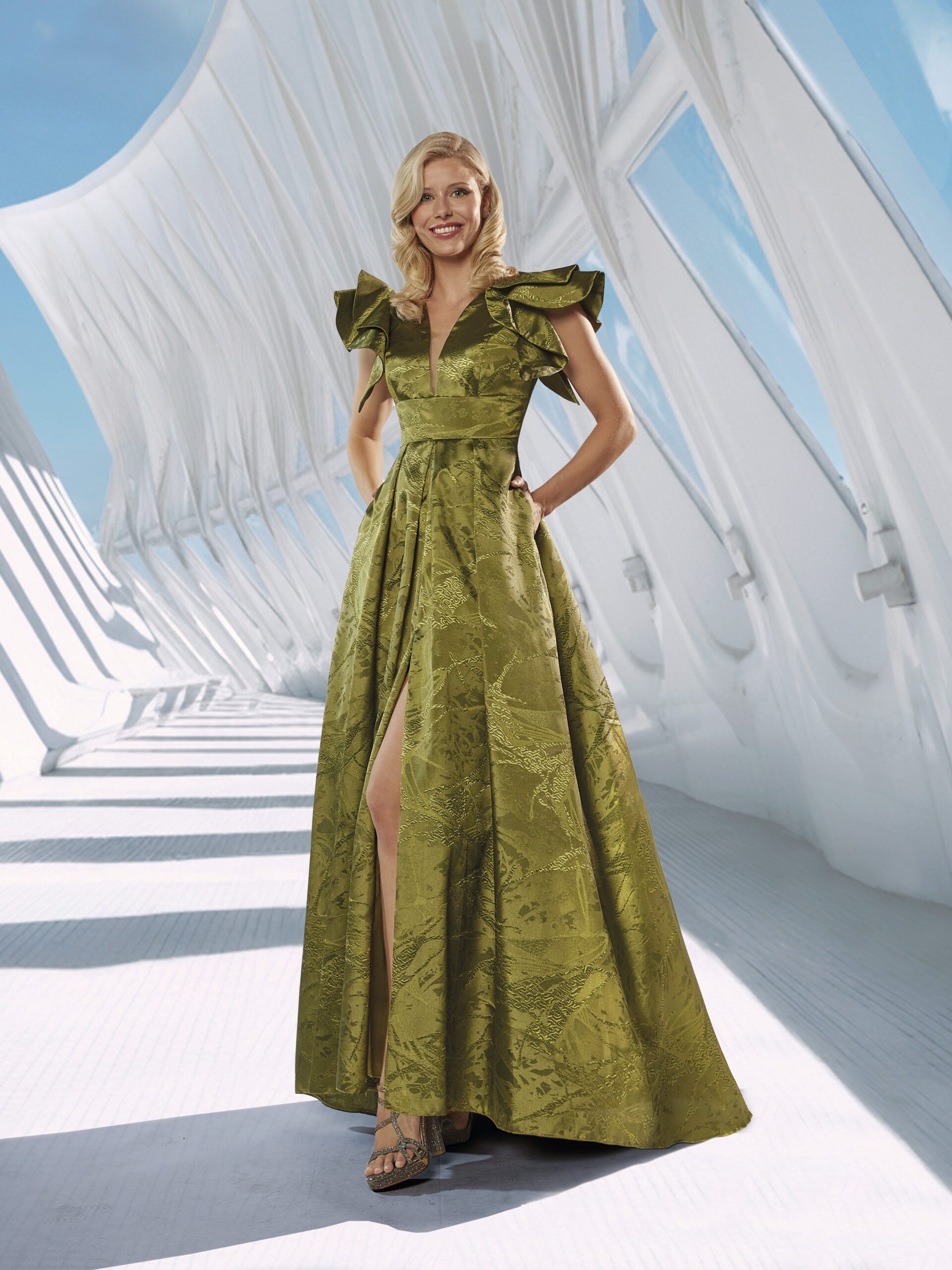 Vestido largo en tono coral con tejido de jacquard satinado que aporta un elegante brillo y textura. Su diseño destaca por las voluminosas mangas con volantes