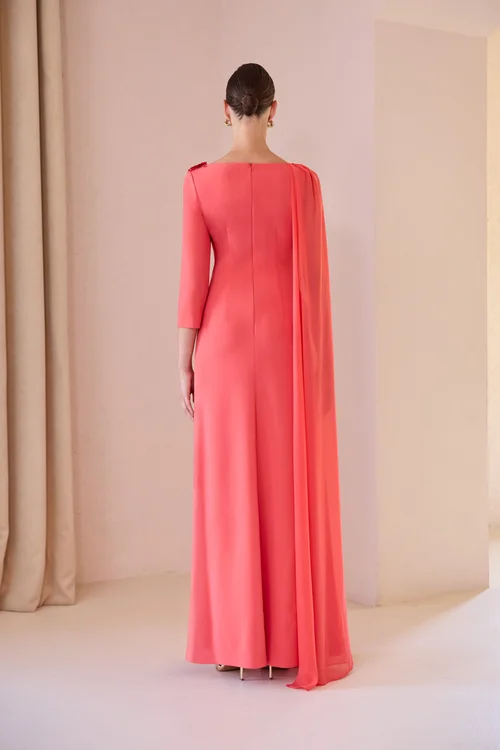 Vestido Carla Ruiz largo, con manga larga, caida de gasa y adorno en la parte superior izquierda del escote.